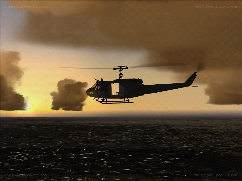 helicopter over ocean at sunset