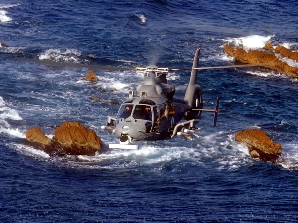 Helicopter over rocky ocean