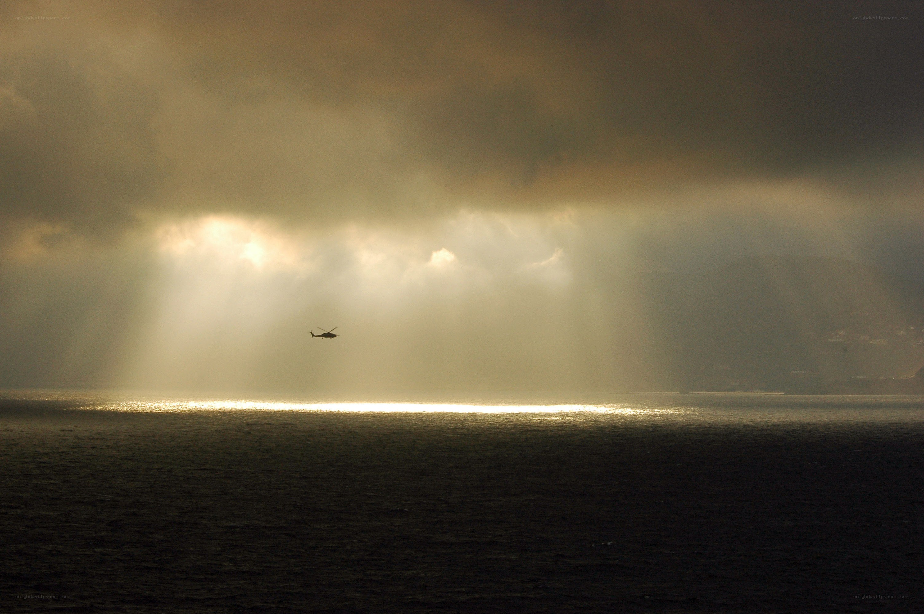 Helicopter over sunlit sea