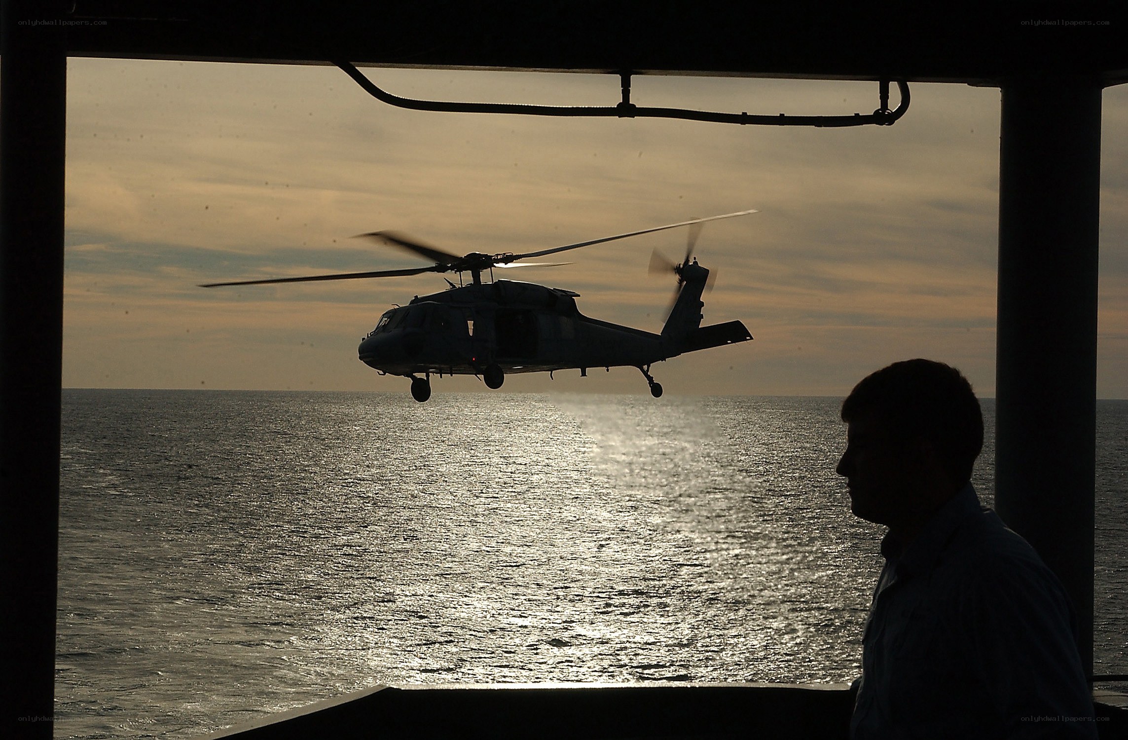 Helicopter over the ocean at sunset