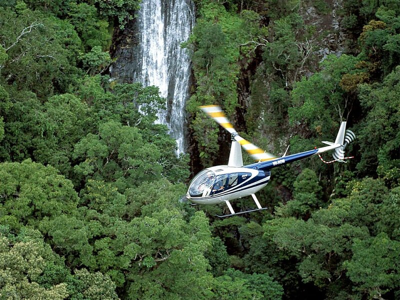 Helicopter over waterfall forest