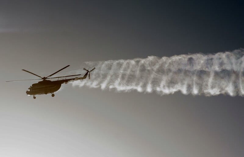Helicopter releasing water trail