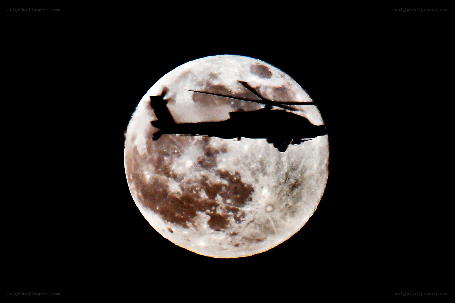 Helicopter silhouetted against the moon