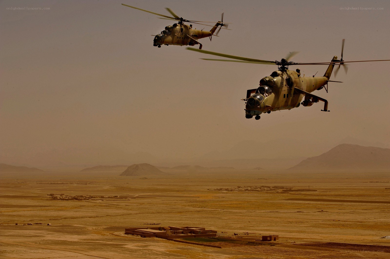 Helicopters flying over desert