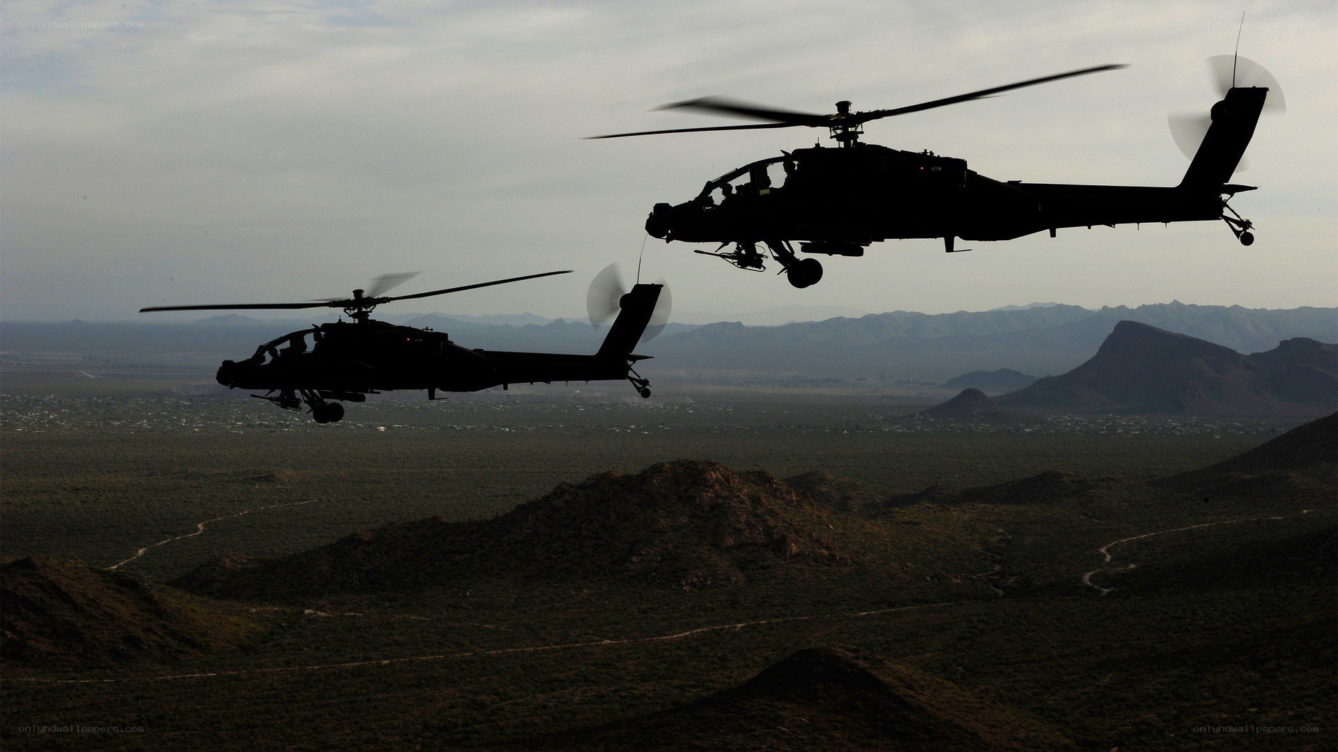 Helicopters flying over desert
