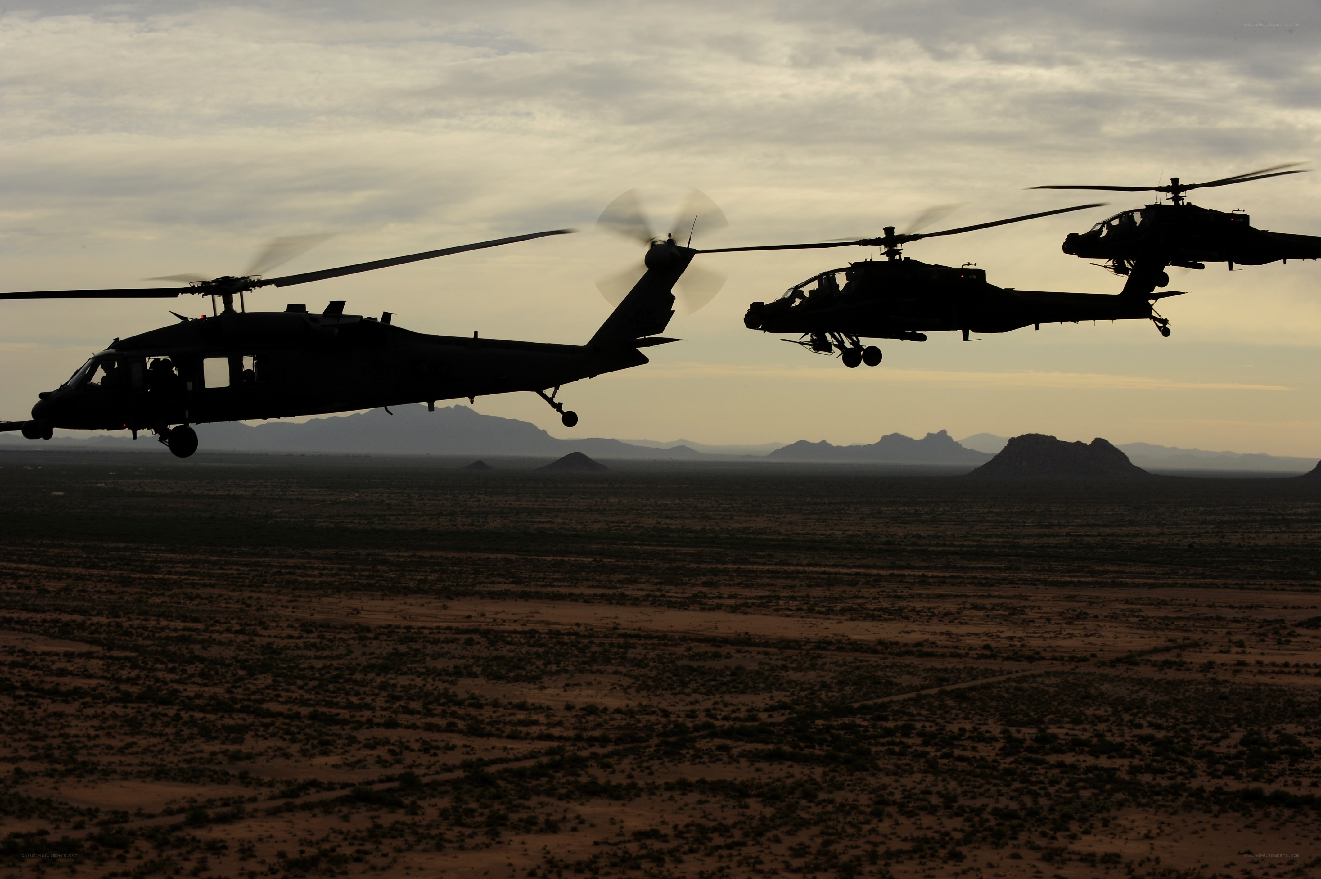 Helicopters flying over desert
