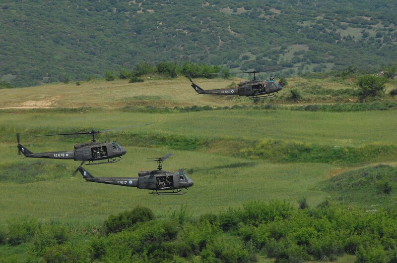 Helicopters flying over green fields