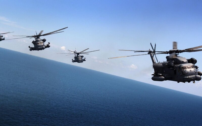 Helicopters flying over ocean