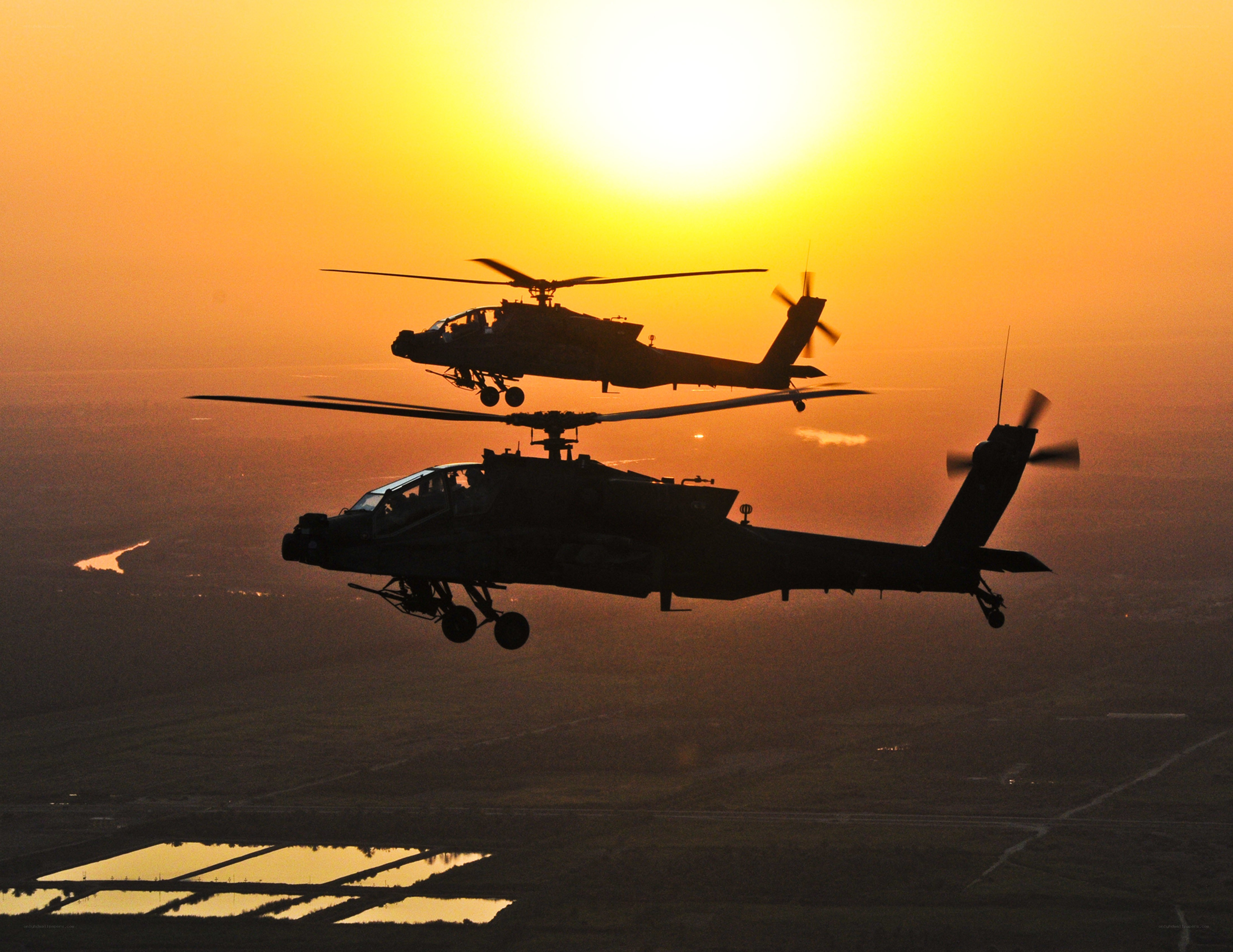 Helicopters in flight at sunset