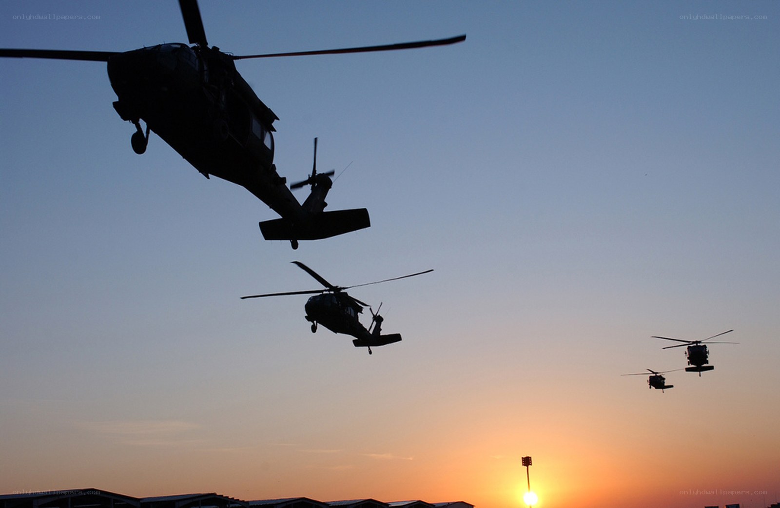Helicopters in formation at sunset