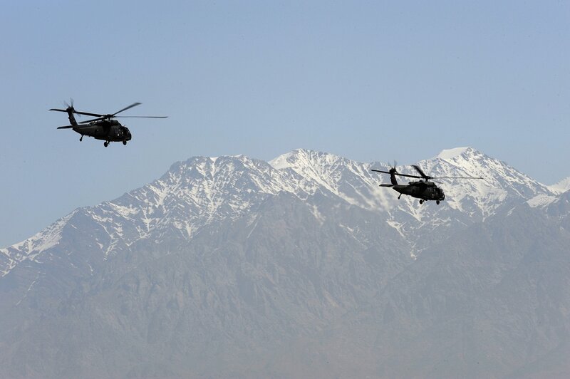 Helicopters over snow-capped mountains