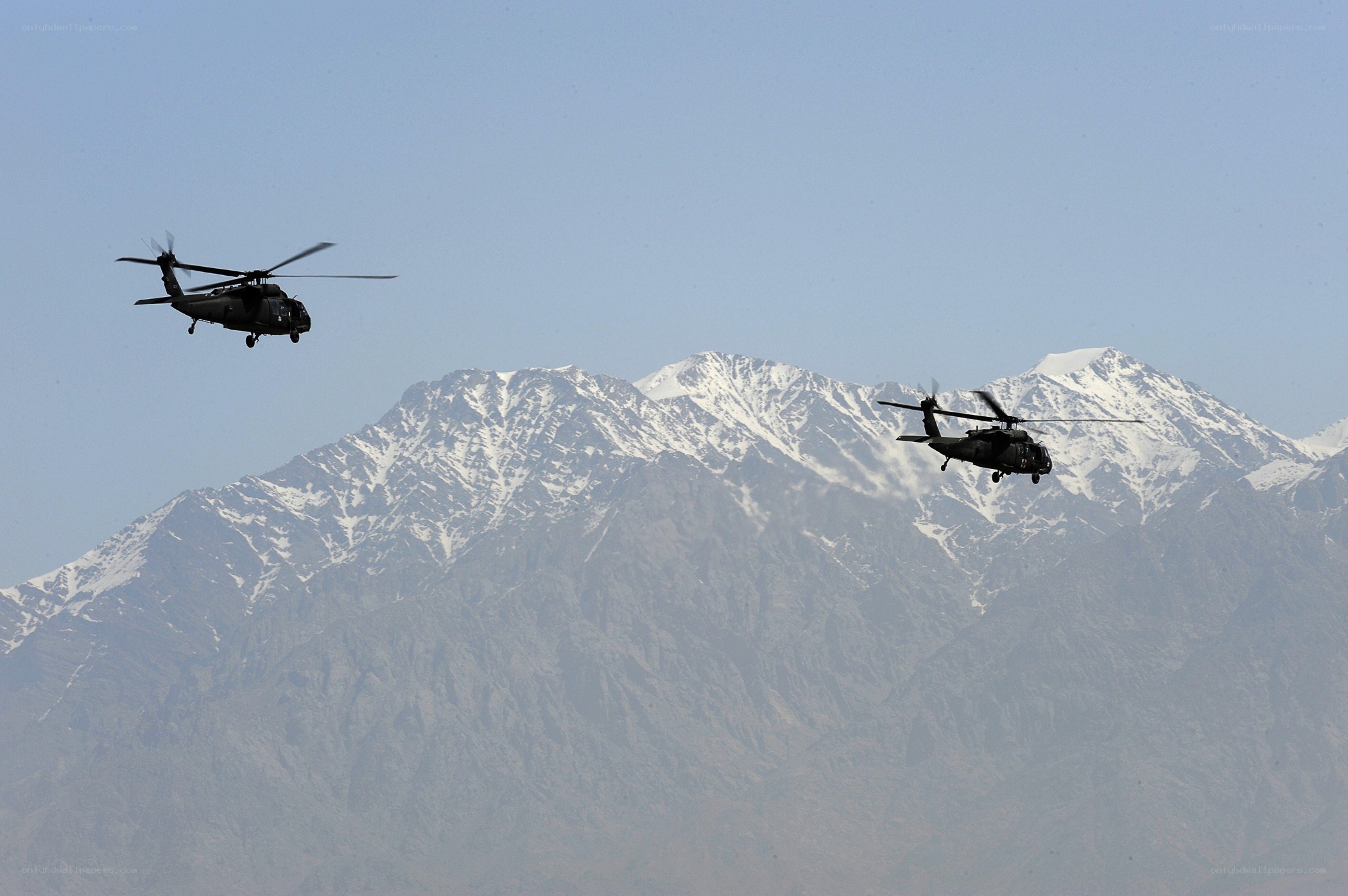 Helicopters over snow-capped mountains