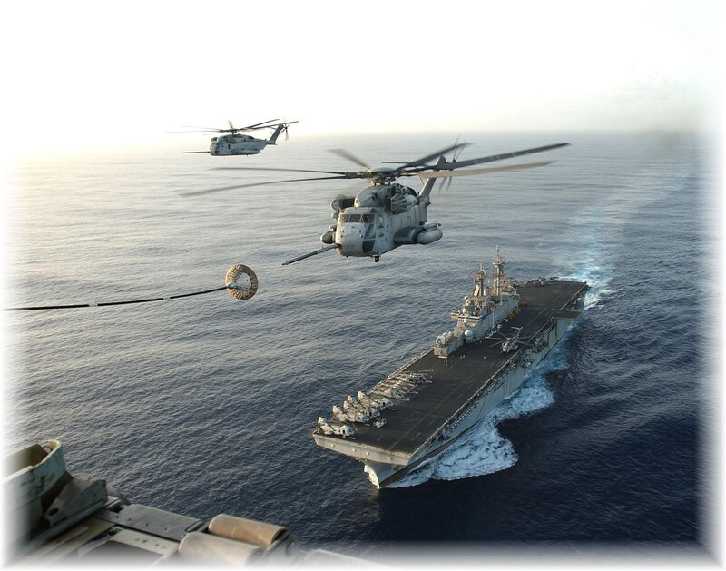 Helicopters refueling over aircraft carrier