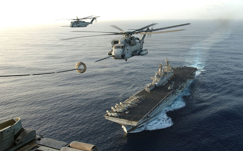Helicopters refueling over aircraft carrier