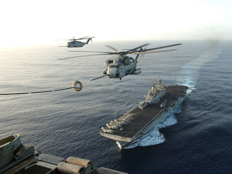 Helicopters refueling over ship
