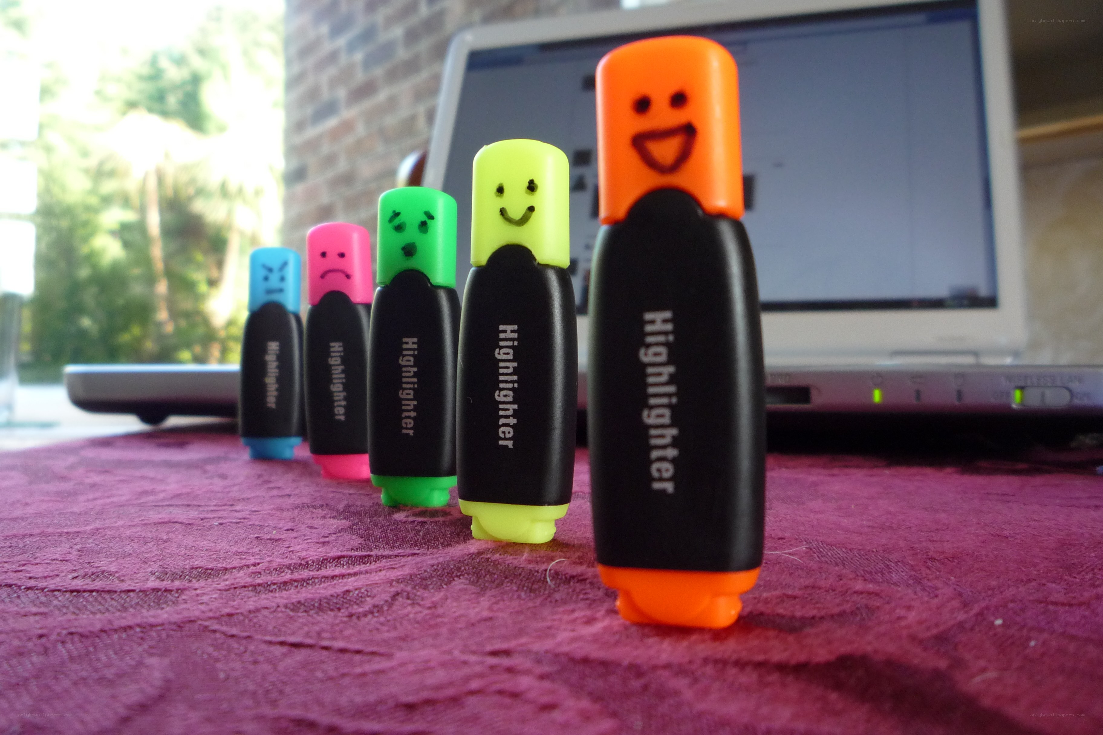highlighters with faces on table