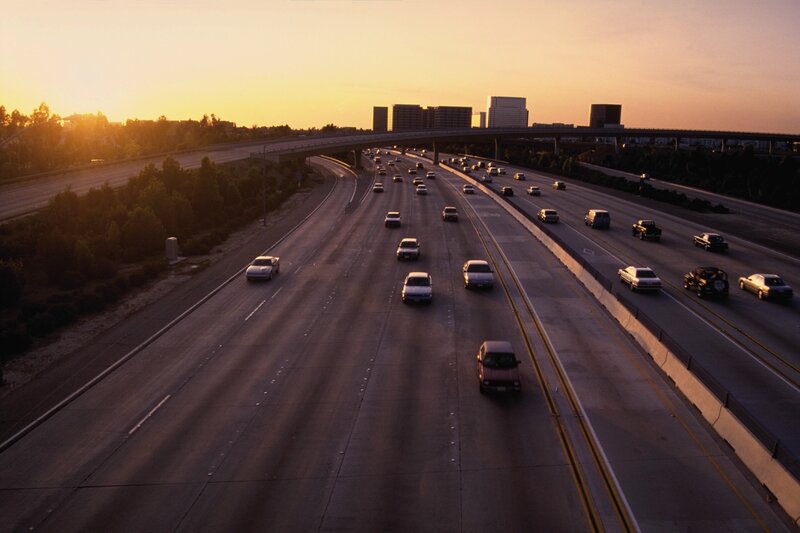 Highway at sunset with city skyline