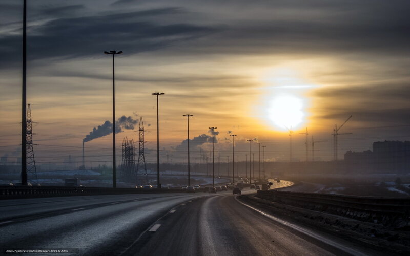Highway at sunset with industrial backdrop