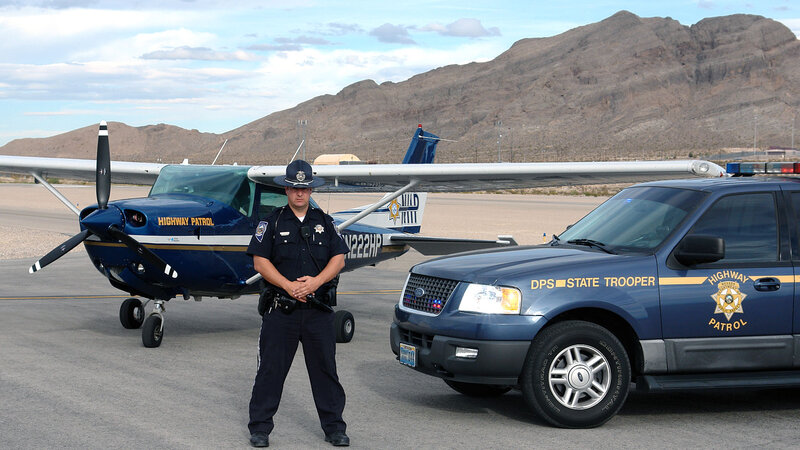 Highway Patrol officer with aircraft and vehicle
