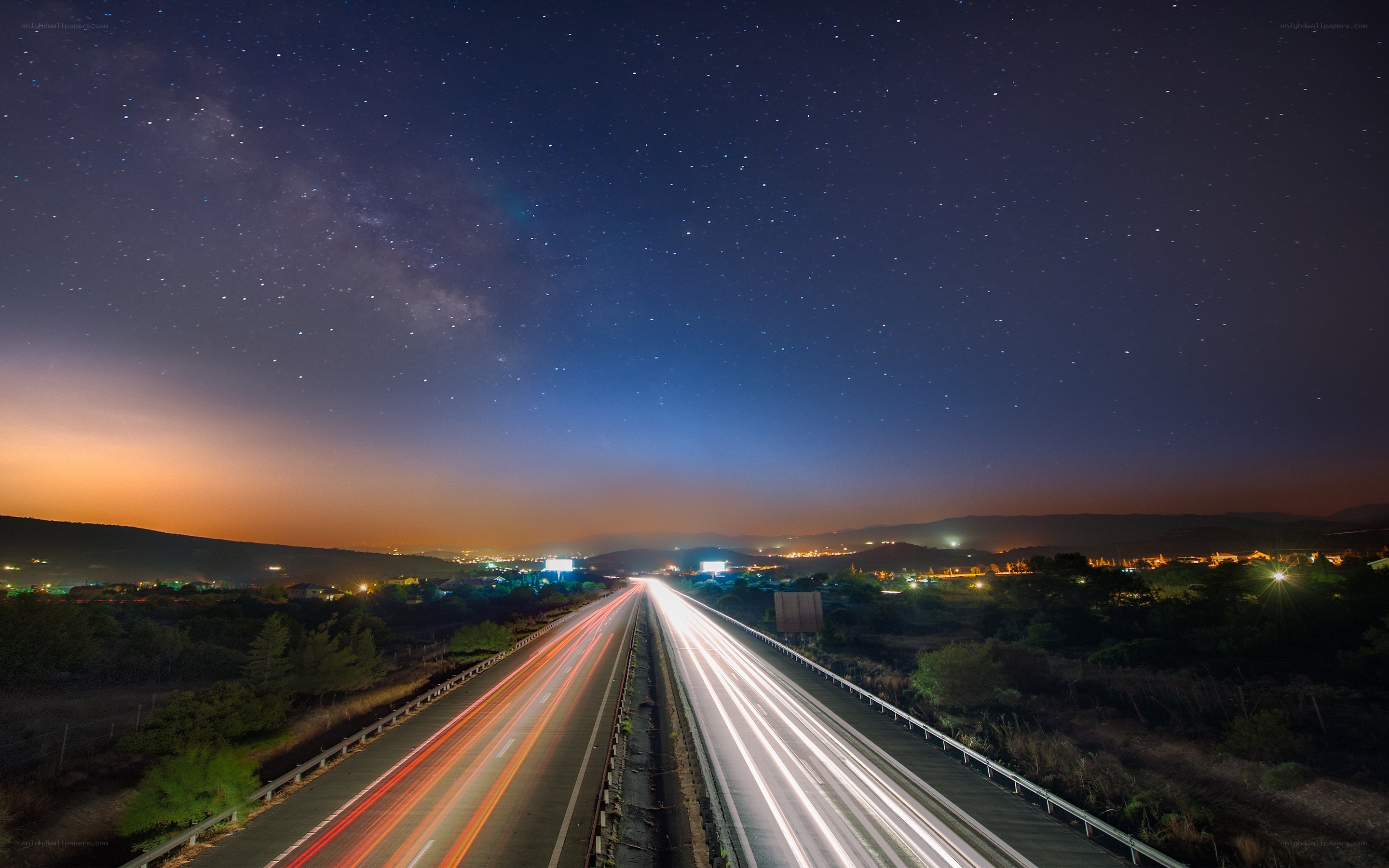 Highway under starry night sky