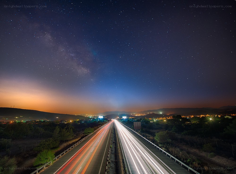 Highway under starry night sky