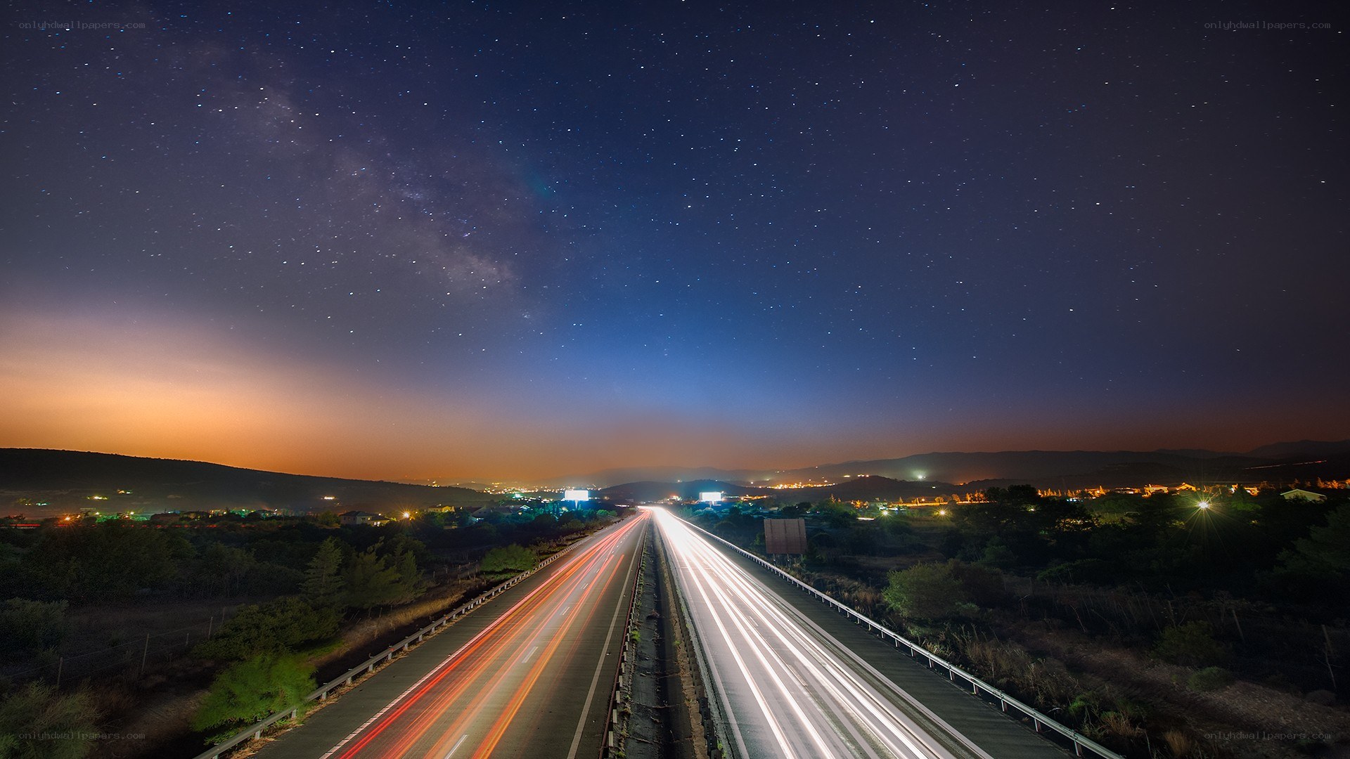 Highway under starry night sky