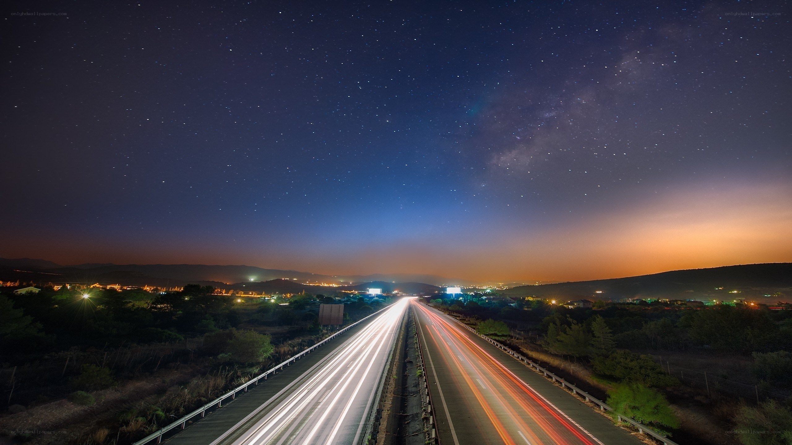 Highway under starry night sky