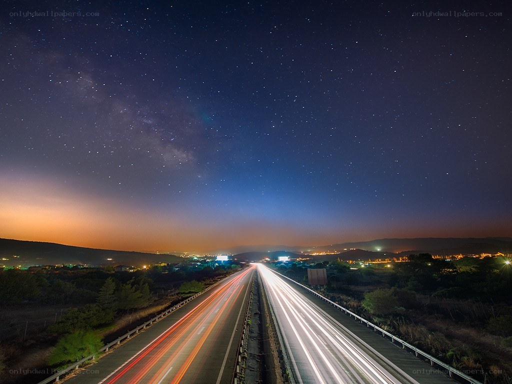 Highway under starry night sky