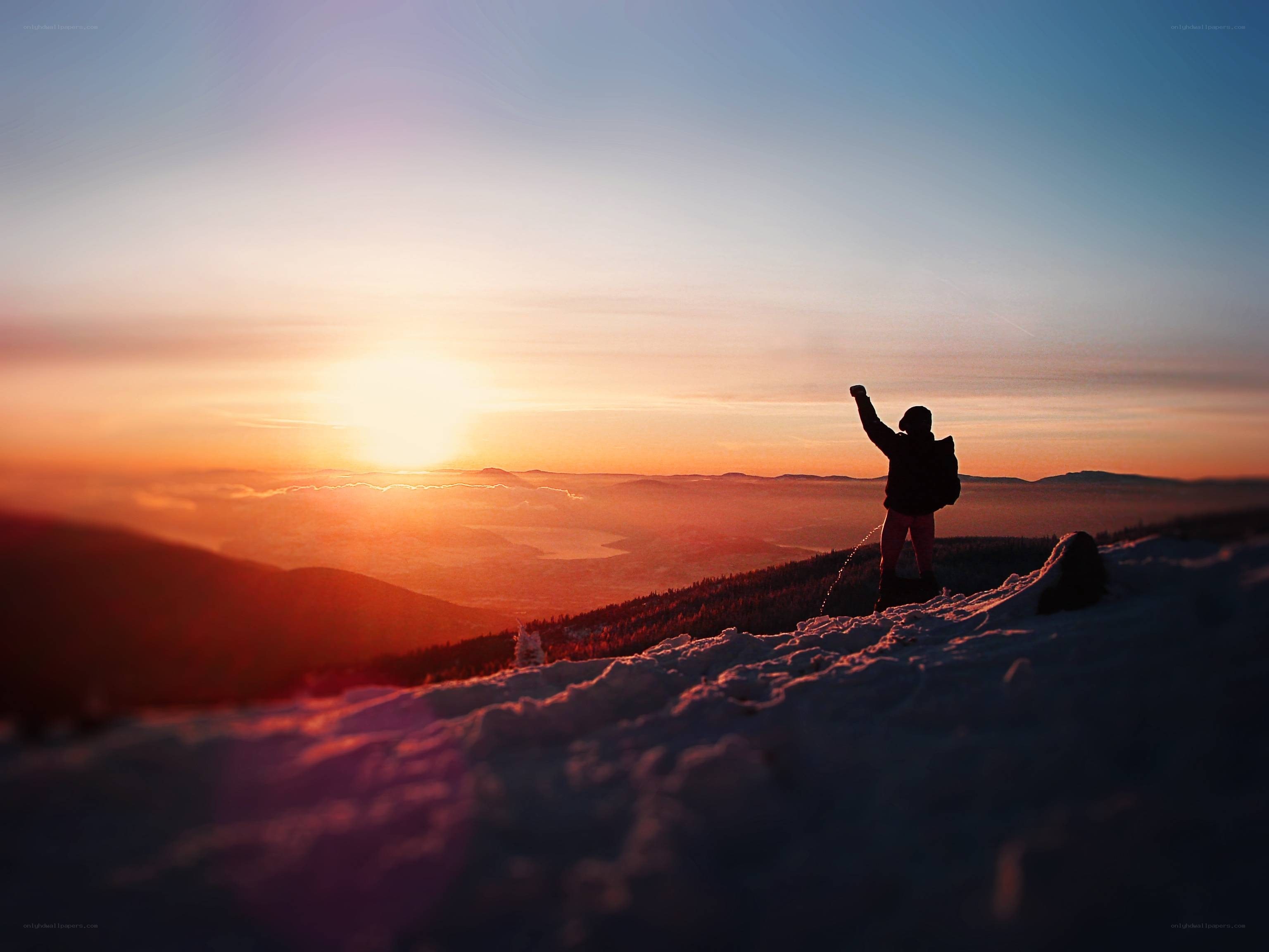Hiker celebrates sunset on mountain