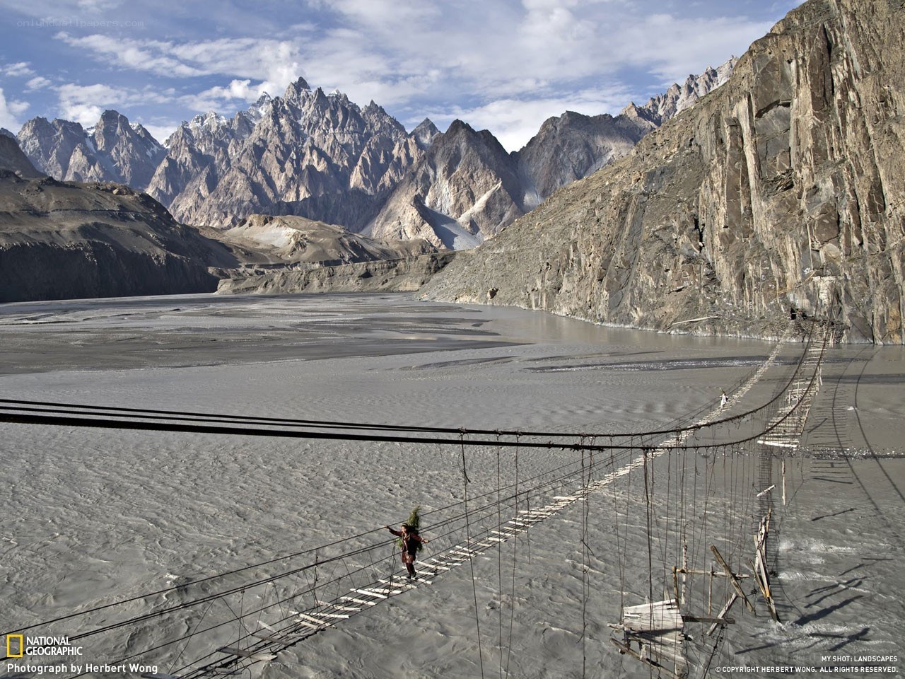 Hiker crossing a suspension bridge