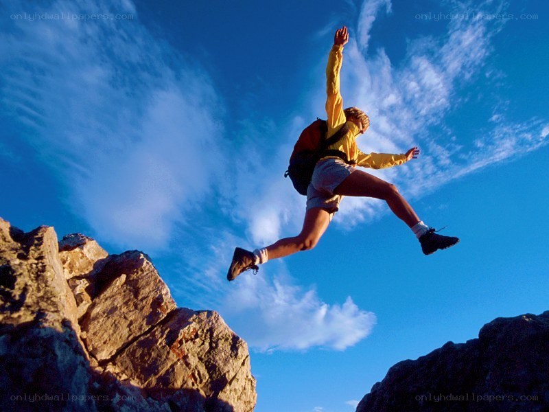Hiker jumping between cliffs