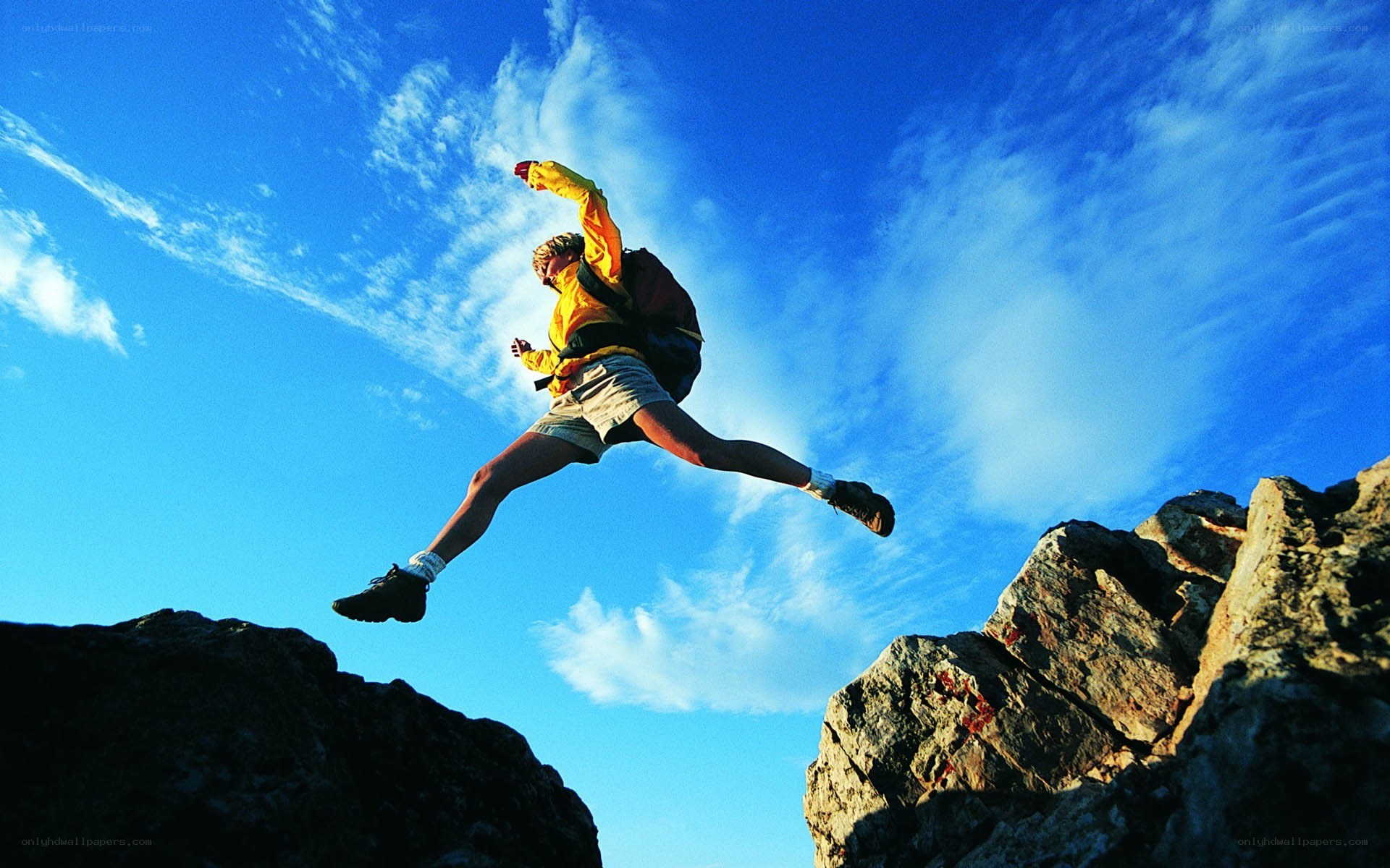 Hiker jumping between rocks