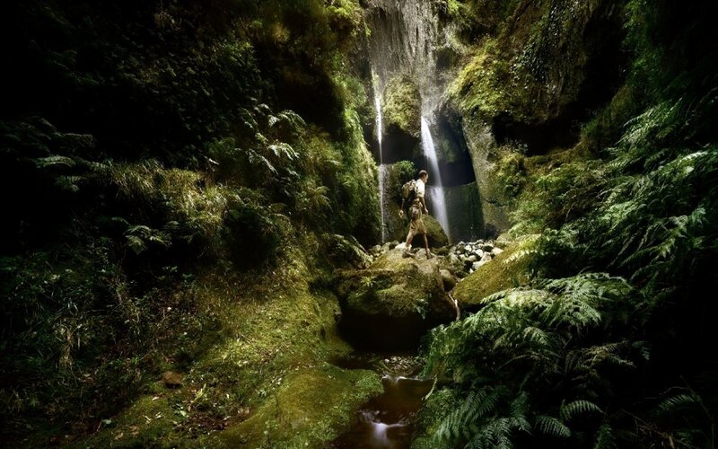 Hiker near waterfall in forest