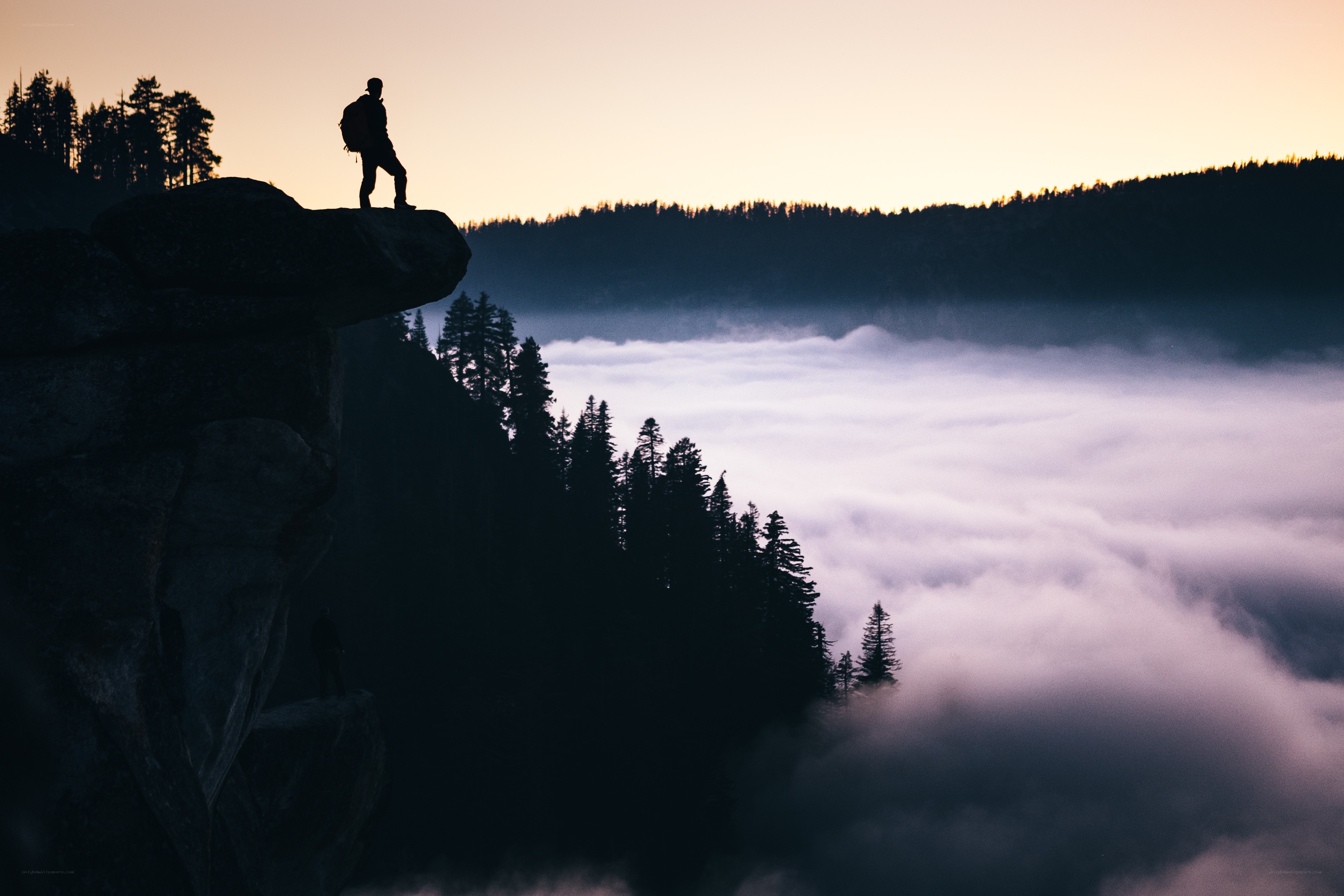 Hiker on a cliff at dawn