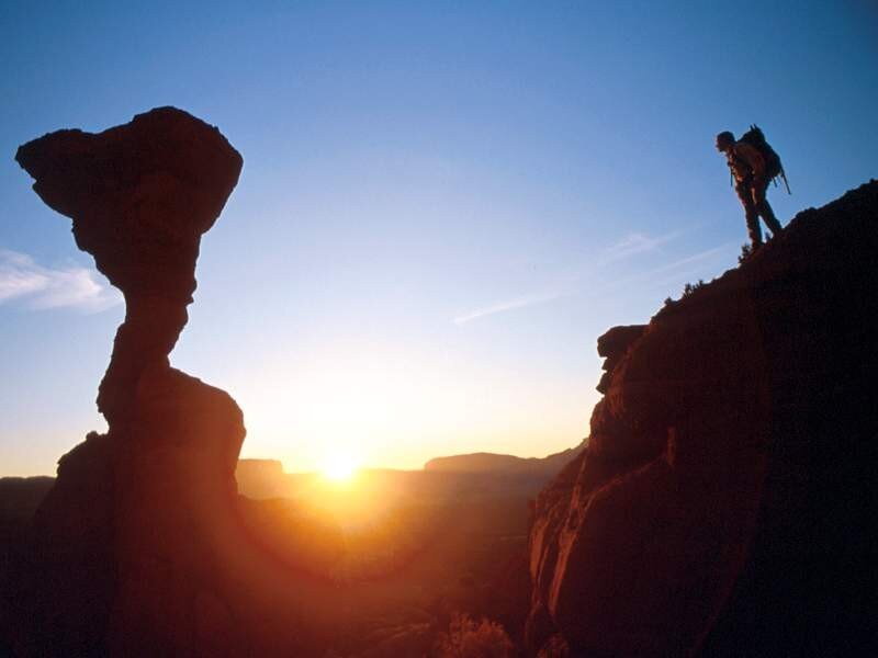 Hiker on a cliff at sunset