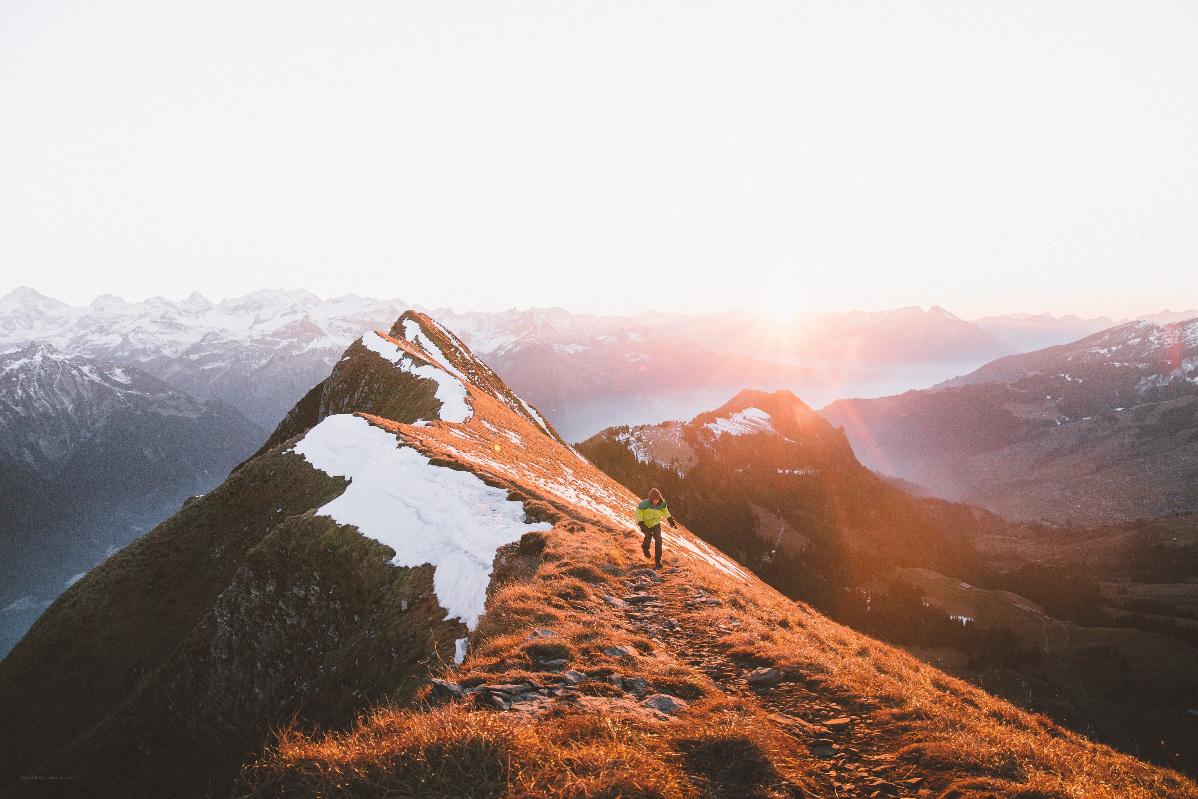 Hiker on a mountain ridge at sunset
