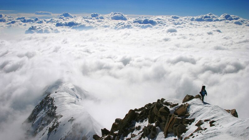 Hiker on a snowy mountain peak