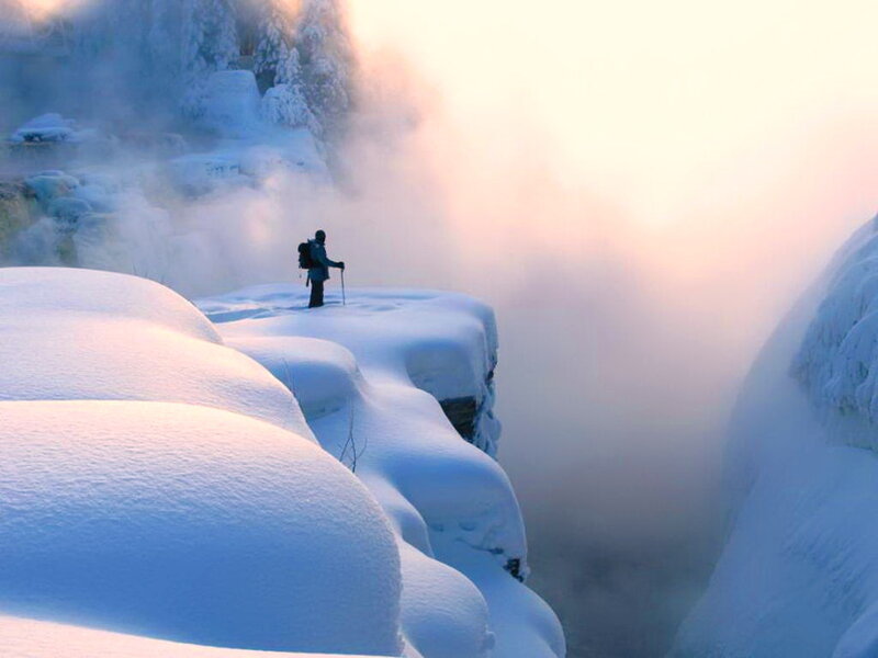 Hiker on Snowy Cliff