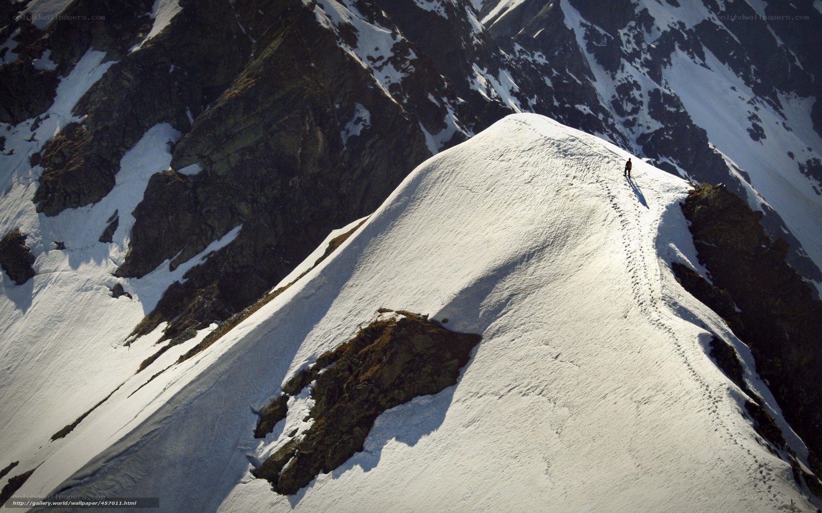 Hiker on snowy mountain ridge