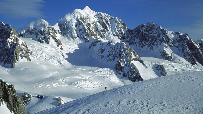 Hiker on snowy mountain slope