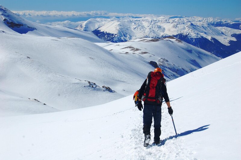 Hiker on snowy mountain slope