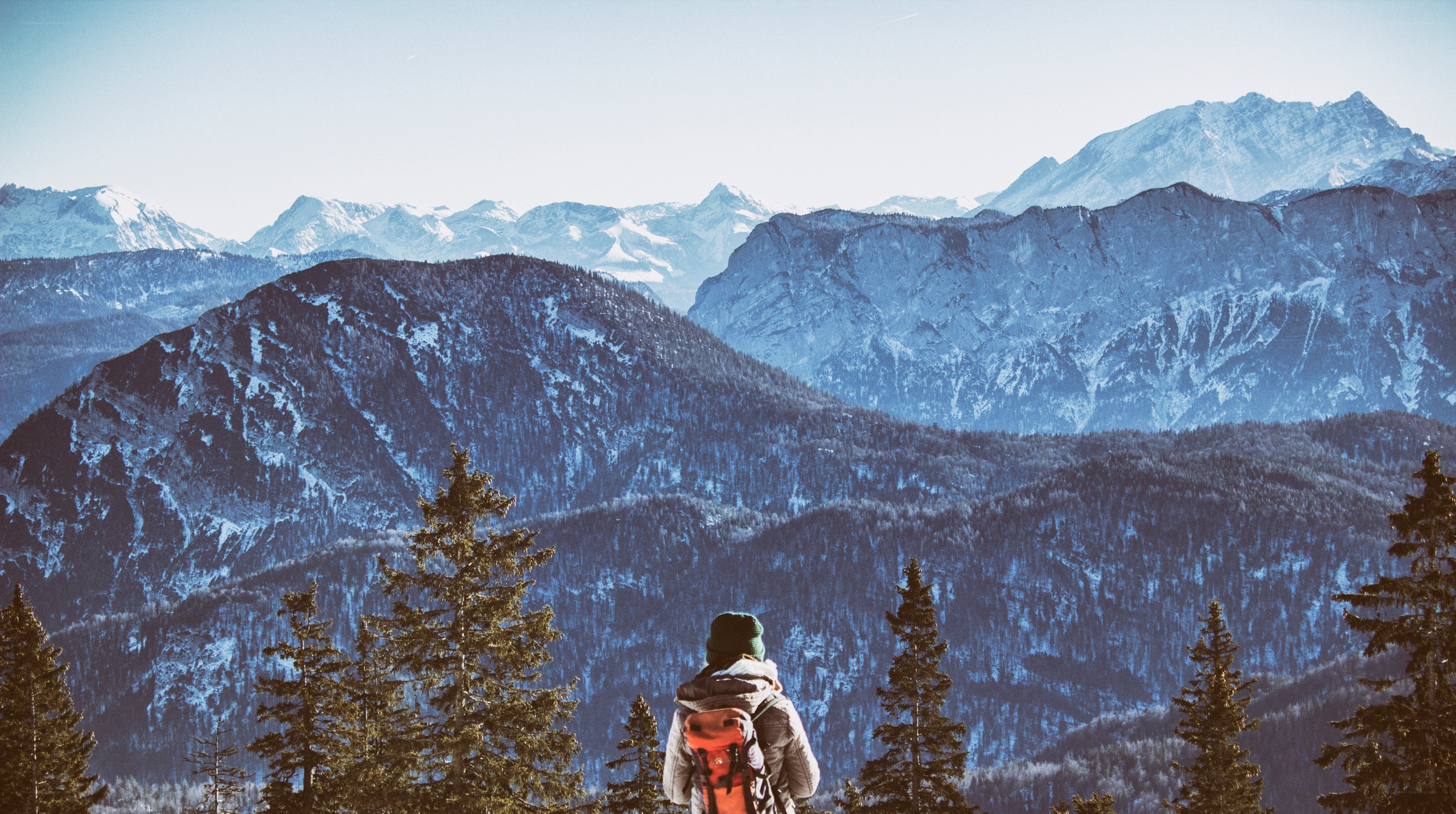 Hiker overlooking snowy mountains