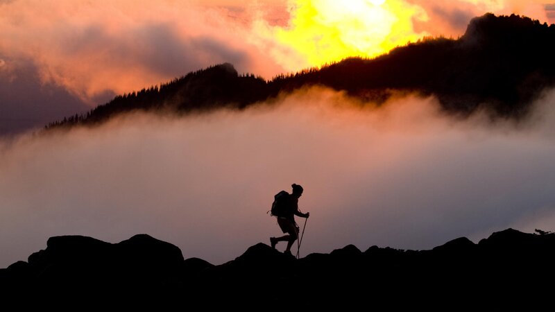 Hiker silhouetted at sunrise