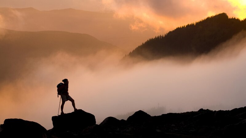 Hiker silhouetted at sunrise