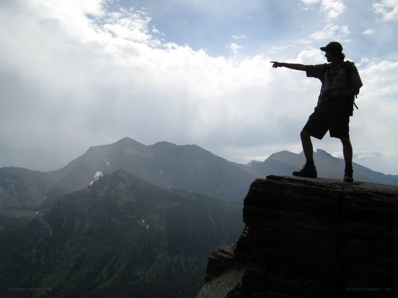 Hiker silhouetted on mountain peak