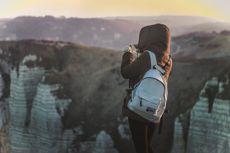 Hiker taking photo at cliff edge