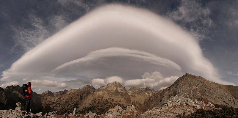 Hiker under lenticular cloud