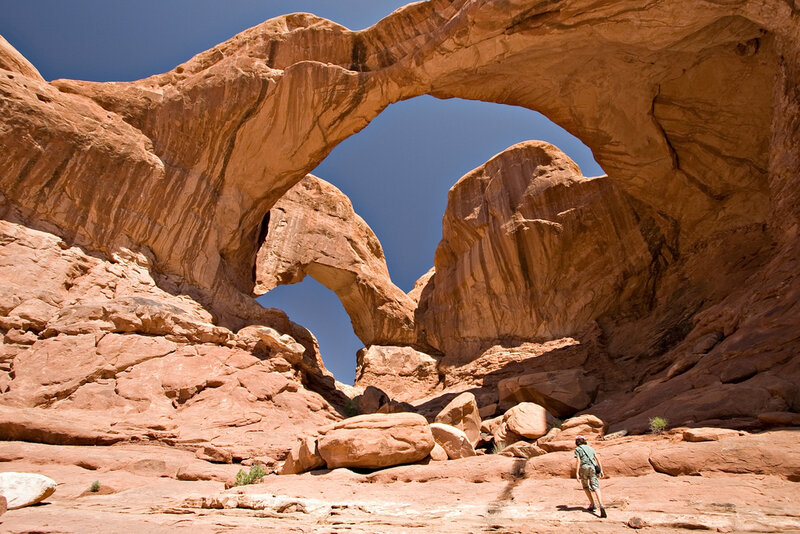 Hiker under Rock Arch