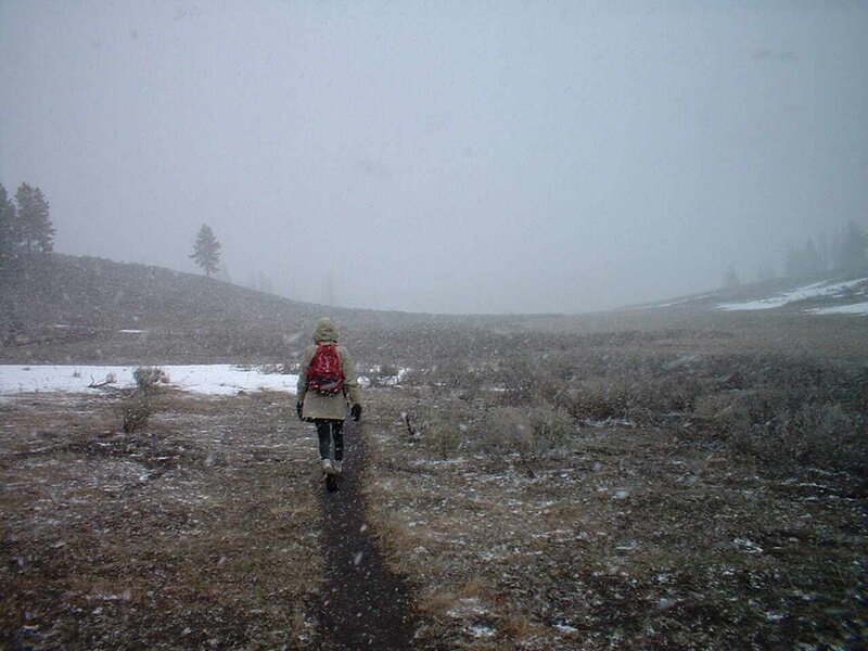 Hiker walks in snowy field