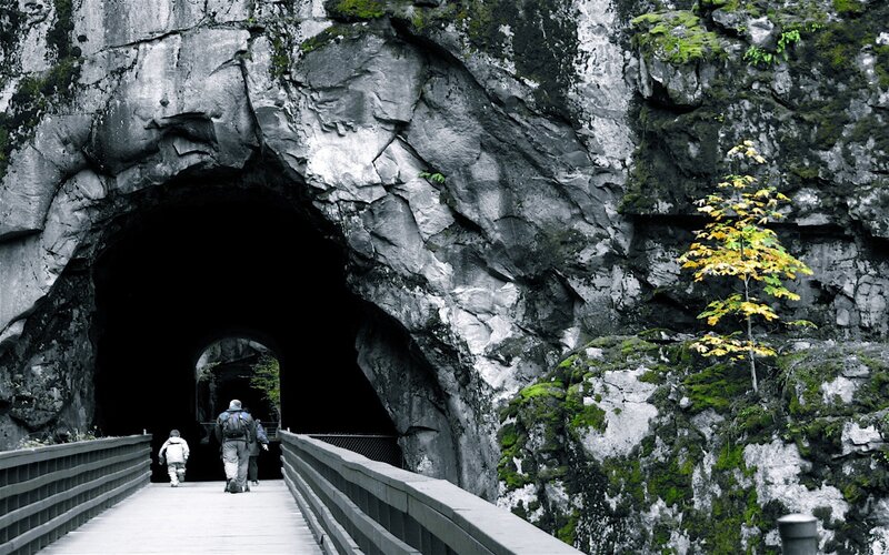Hikers enter a tunnel in the mountains